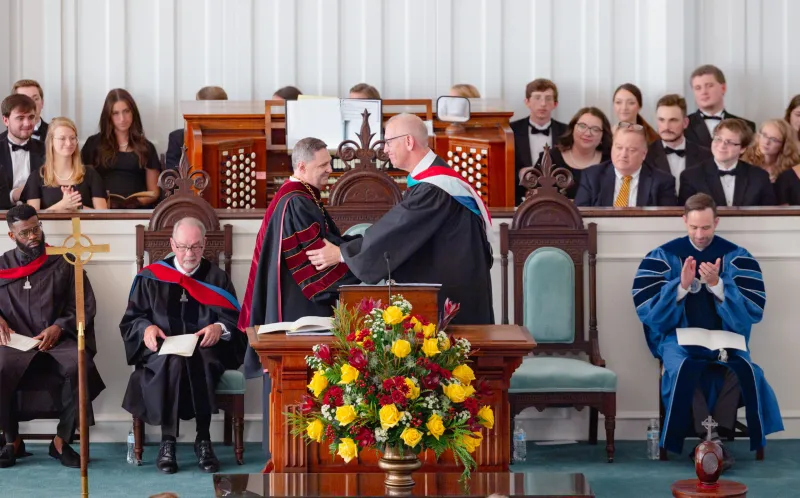 Erskine College's newly-installed President Dr. Steve Adamson shakes hands with Board of Trustees Chair Mike Whitehurst.