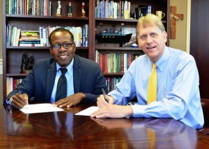 Joshua Paul of Build and Bridge, left, and Southern Wesleyan University President Todd Voss, sign a Memorandum of Understanding for a collaboration that will help build sustainable communities in economically strapped areas of Haiti by supporting entrepreneurship in business, fishing technology and agro technology. 
